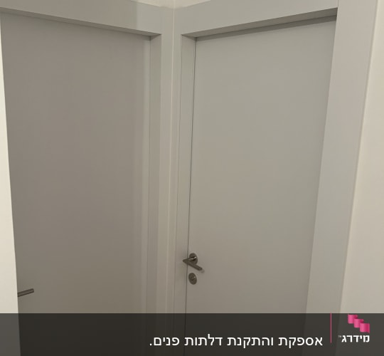 שתי דלתות לבנות עם ידיות מתכת